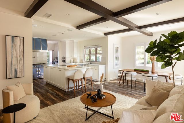 a living room with furniture kitchen view and a large window