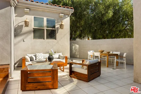 a backyard of a house with table and chairs