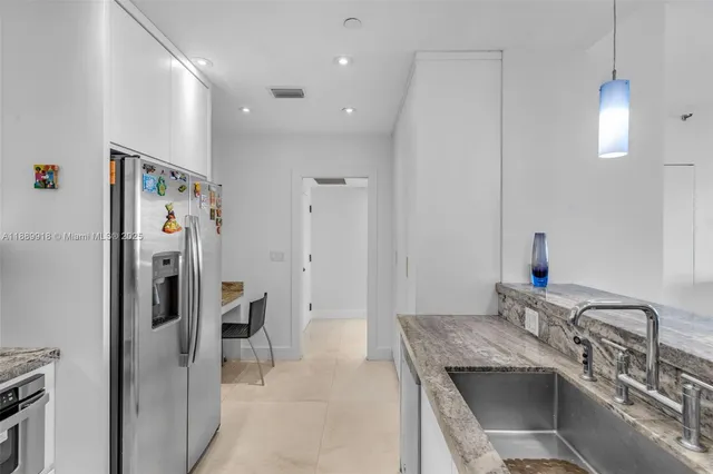 a kitchen with stainless steel appliances granite countertop a refrigerator and a sink