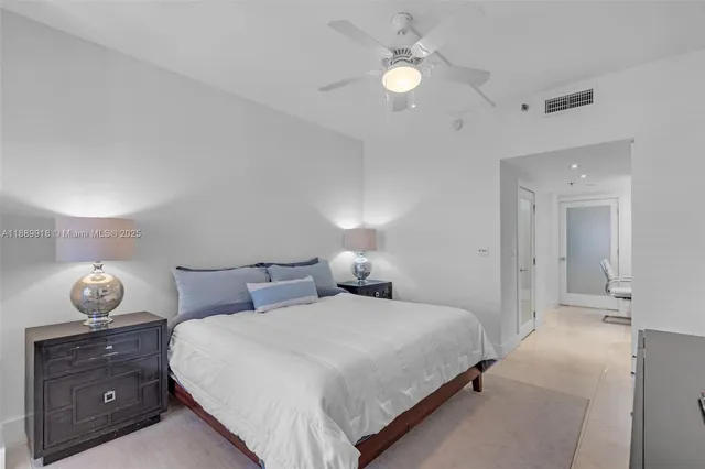 a bedroom with a lamp and a chandelier fan