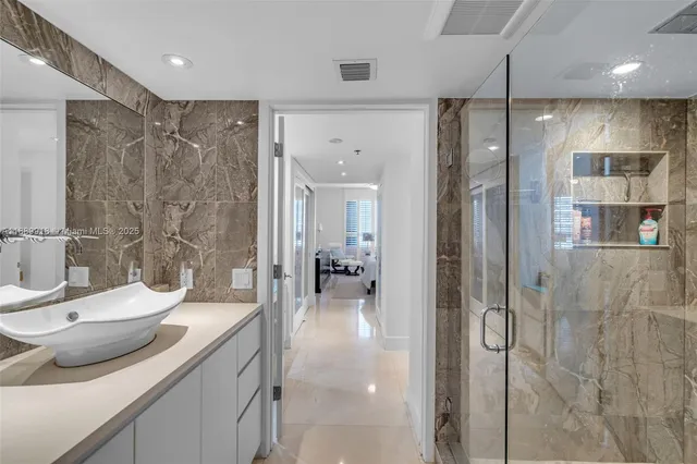 a bathroom with a granite countertop sink mirror and shower