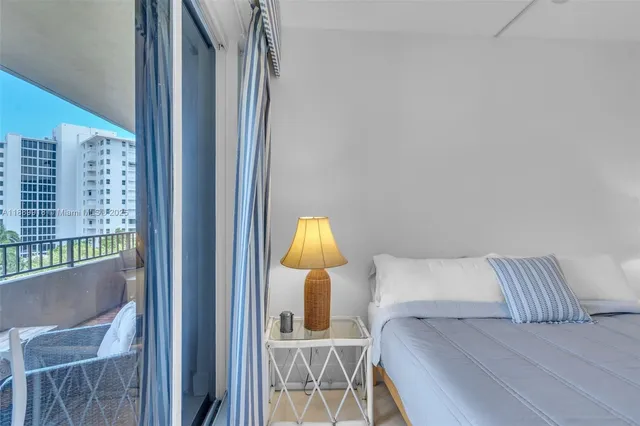 a bedroom with a bed lamp and a potted plant next to a window