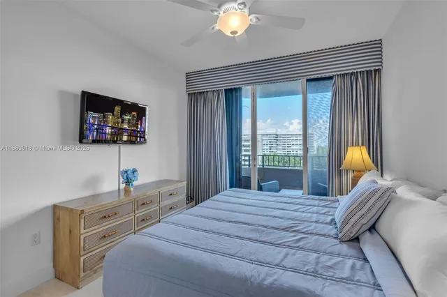 a bedroom with a bed a large window and a flat tv screen