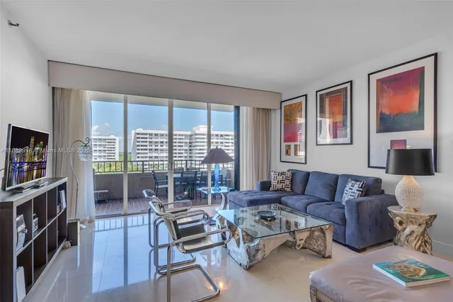 a living room with furniture a bookshelf and a flat screen tv