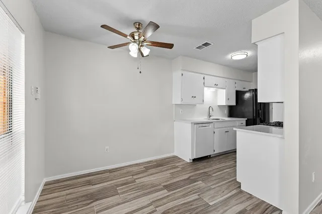 a kitchen with a refrigerator and white cabinets