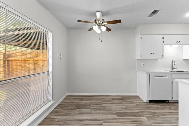 a view of a kitchen with wooden floor and a window