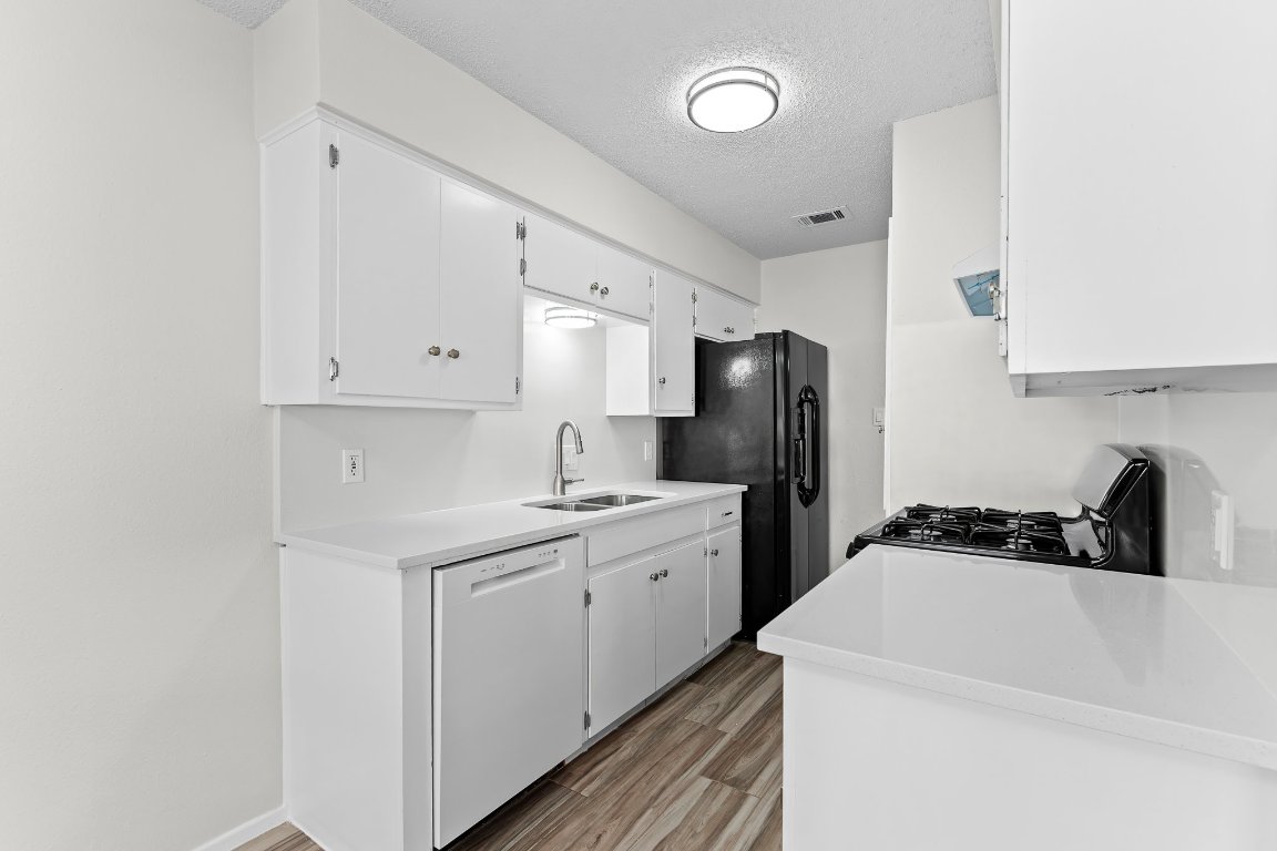 10807 Lambert Circle, Unit A Austin, TX 78758 - Photo 14 of 39 a kitchen with a sink a stove and refrigerator