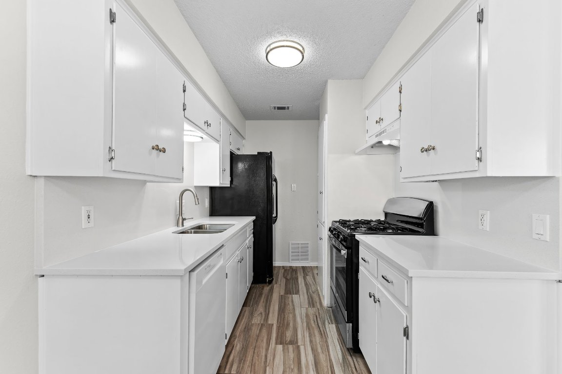 10807 Lambert Circle, Unit A Austin, TX 78758 - Photo 16 of 39 a kitchen with a sink a stove and refrigerator