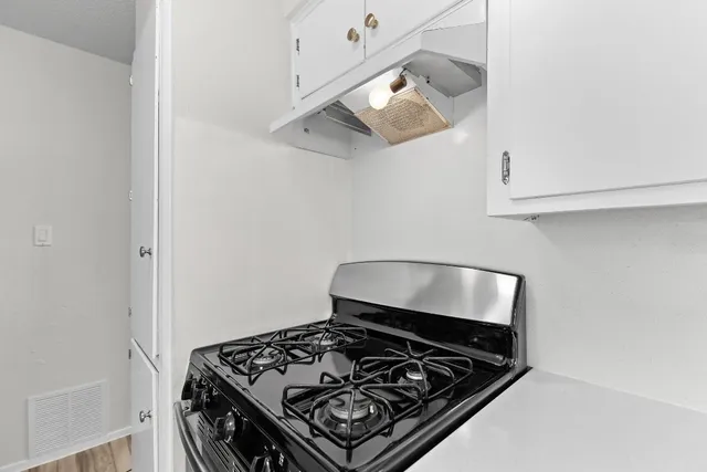a stove top oven sitting inside of a kitchen