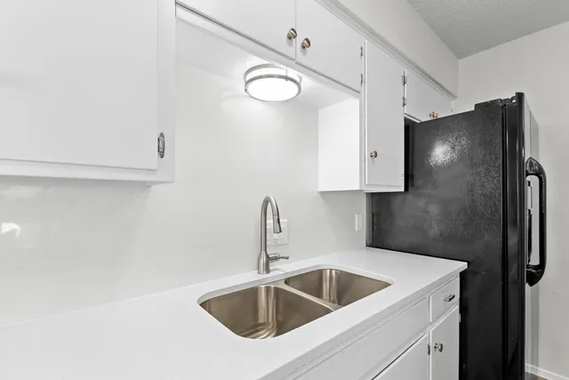 a kitchen with stainless steel appliances a sink a refrigerator and cabinets