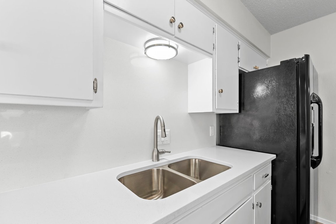 10807 Lambert Circle, Unit A Austin, TX 78758 - Photo 19 of 39 a kitchen with stainless steel appliances a sink a refrigerator and cabinets