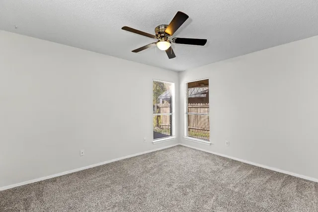 a view of an empty room with a ceiling fan