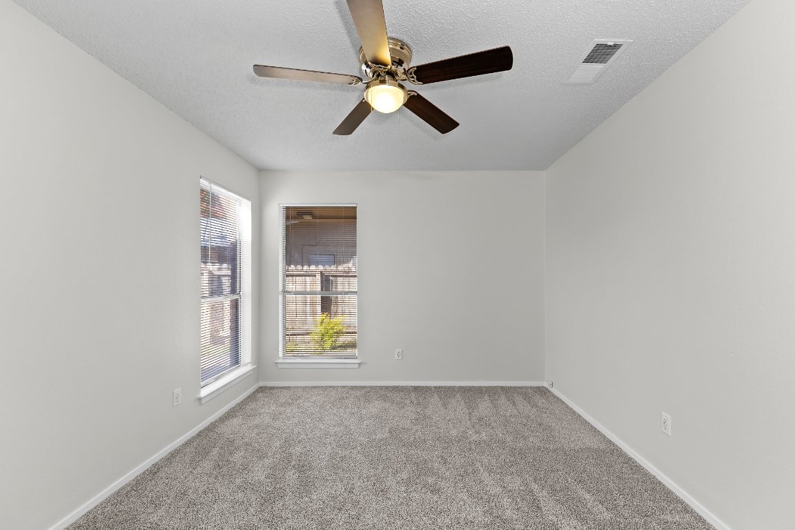10807 Lambert Circle, Unit A Austin, TX 78758 - Photo 28 of 39 an empty room with windows and chandelier fan