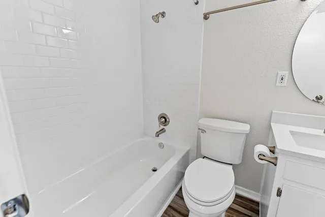 a white toilet sitting next to a bath tub