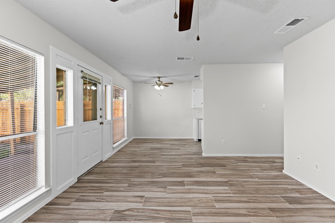 10807 Lambert Circle, Unit A Austin, TX 78758 - Photo 6 of 39 a view of an empty room with a window and a ceiling fan