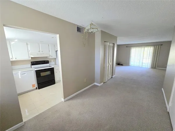 a view of a kitchen with refrigerator and window