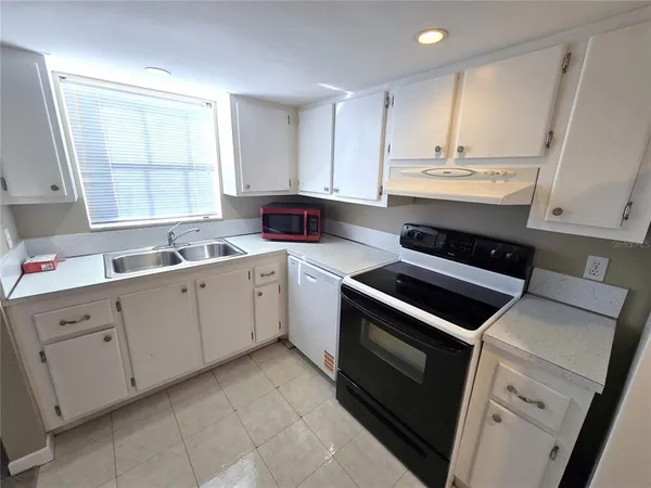 a kitchen with cabinets appliances and a window