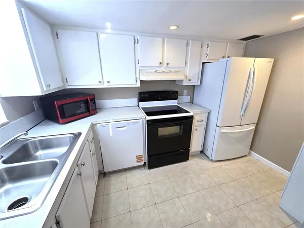 a kitchen with a refrigerator sink and cabinets