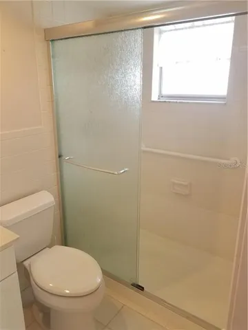 a white toilet sitting next to a shower