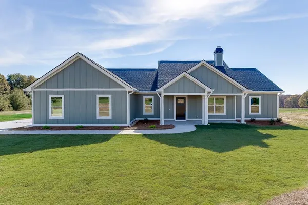 a front view of a house with a garden and deck