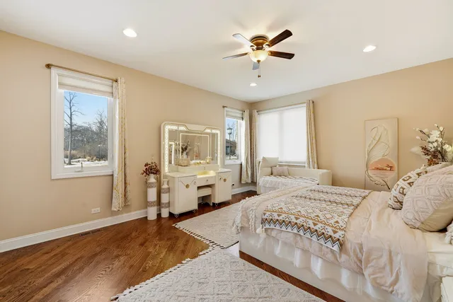 a spacious bedroom with a large bed a chandelier and windows