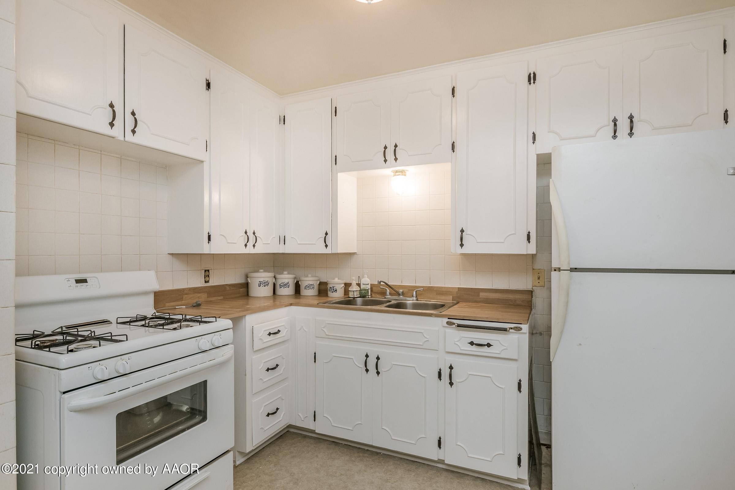 4412 South Lipscomb Street Amarillo, TX 79110 - Photo 5 of 18 a kitchen with cabinets appliances a sink and a counter top