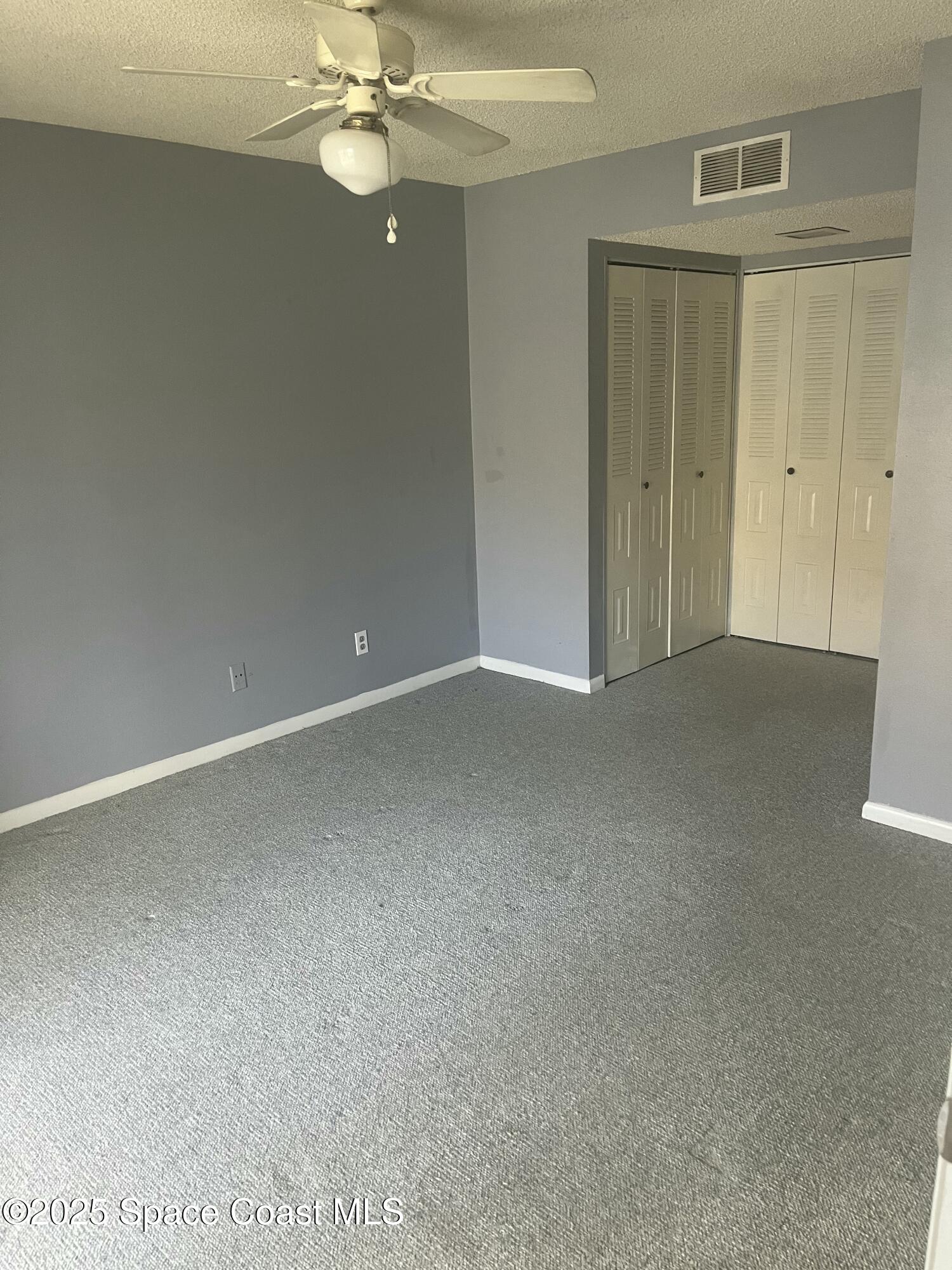 1624 Sunny Brook Lane, Unit C203 Palm Bay, FL 32905 - Photo 13 of 16 a view of a room with a ceiling fan and closet