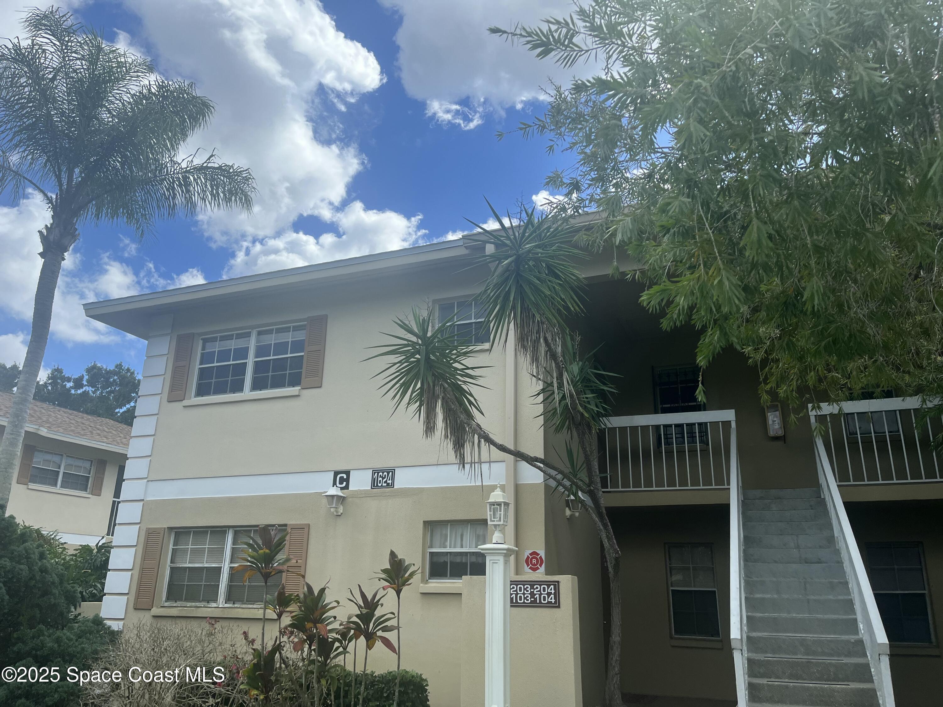 1624 Sunny Brook Lane, Unit C203 Palm Bay, FL 32905 - Photo 3 of 16 a front view of house along with deck and outdoor seating