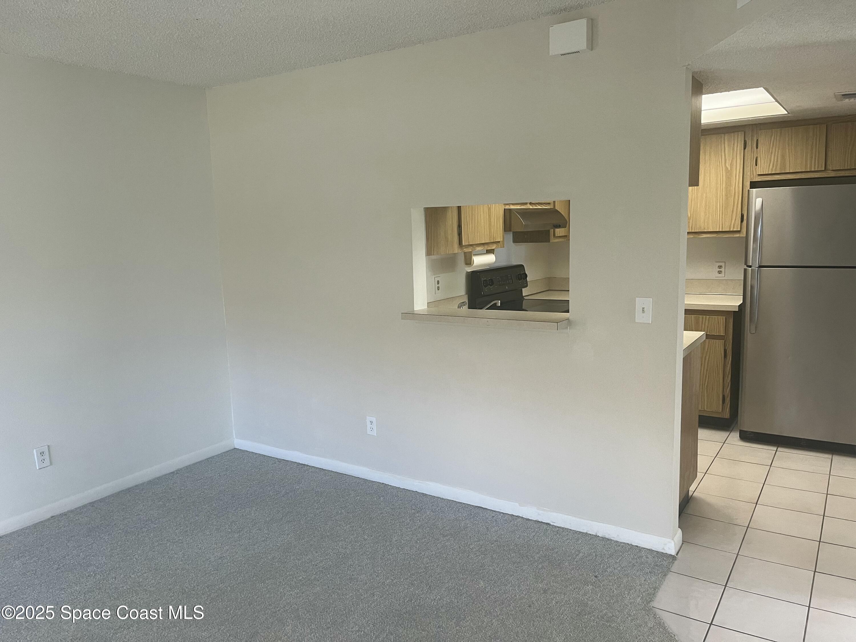 1624 Sunny Brook Lane, Unit C203 Palm Bay, FL 32905 - Photo 10 of 16 a view of a refrigerator in kitchen and an empty room