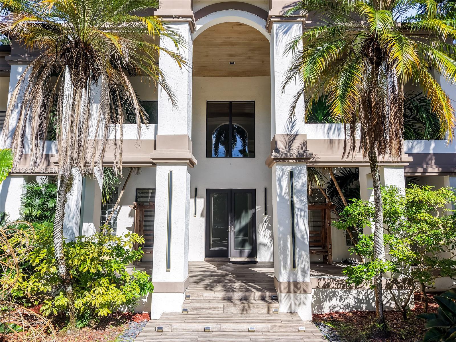 10395 Southwest 67th Avenue Pinecrest, FL 33156 - Photo 4 of 94 a front view of a house with a yard