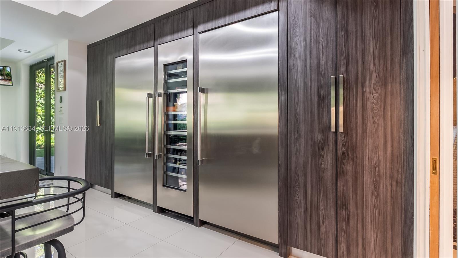 10395 Southwest 67th Avenue Pinecrest, FL 33156 - Photo 54 of 94 a kitchen with a refrigerator and wooden floor