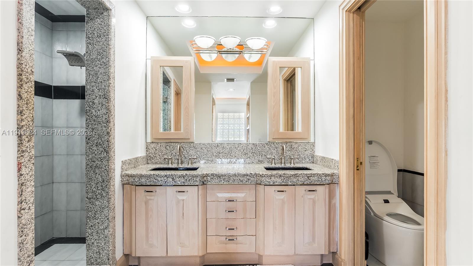 10395 Southwest 67th Avenue Pinecrest, FL 33156 - Photo 65 of 94 a bathroom with a granite countertop sink and a mirror