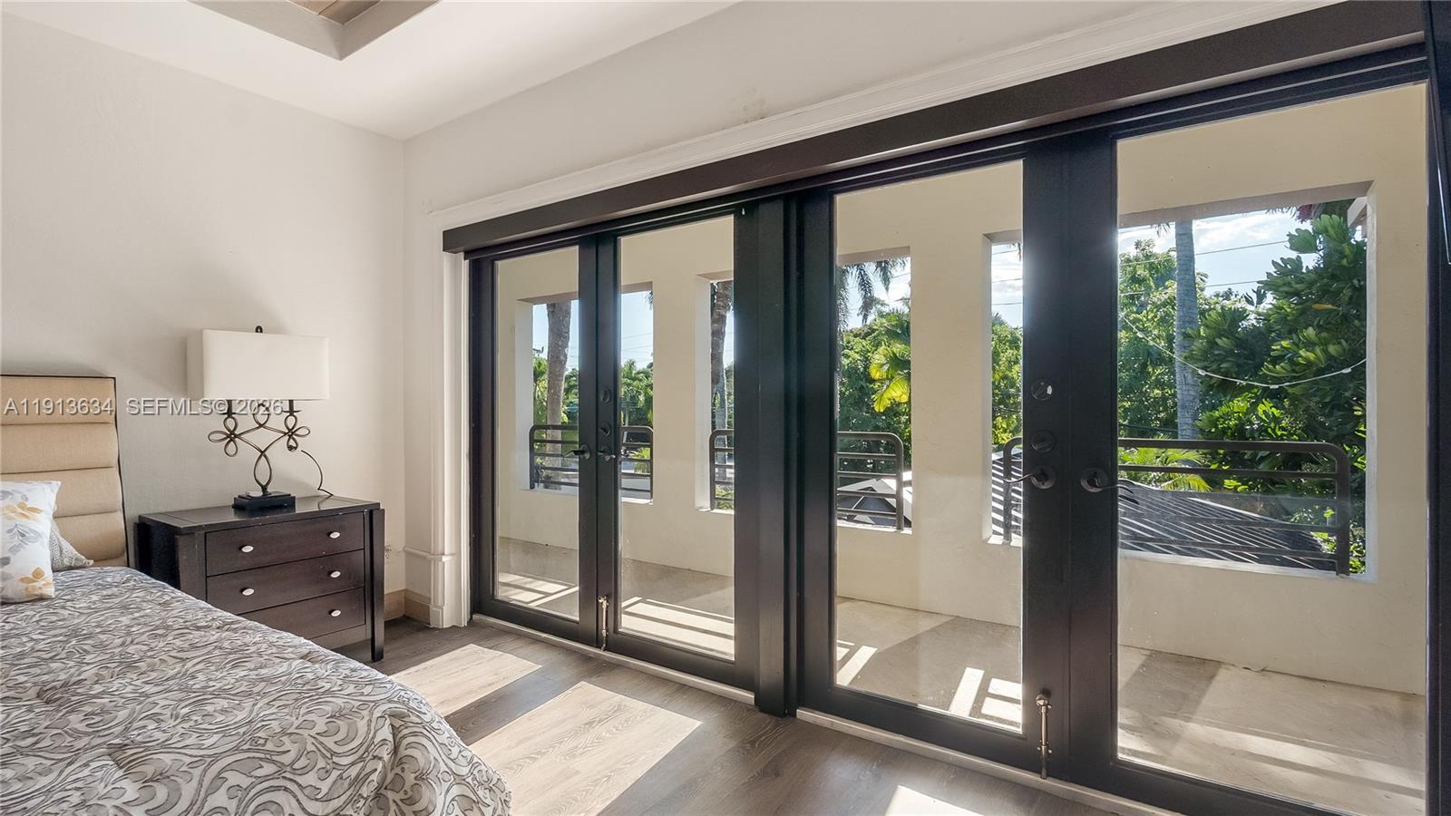 10395 Southwest 67th Avenue Pinecrest, FL 33156 - Photo 69 of 94 a bedroom with a bed and large windows