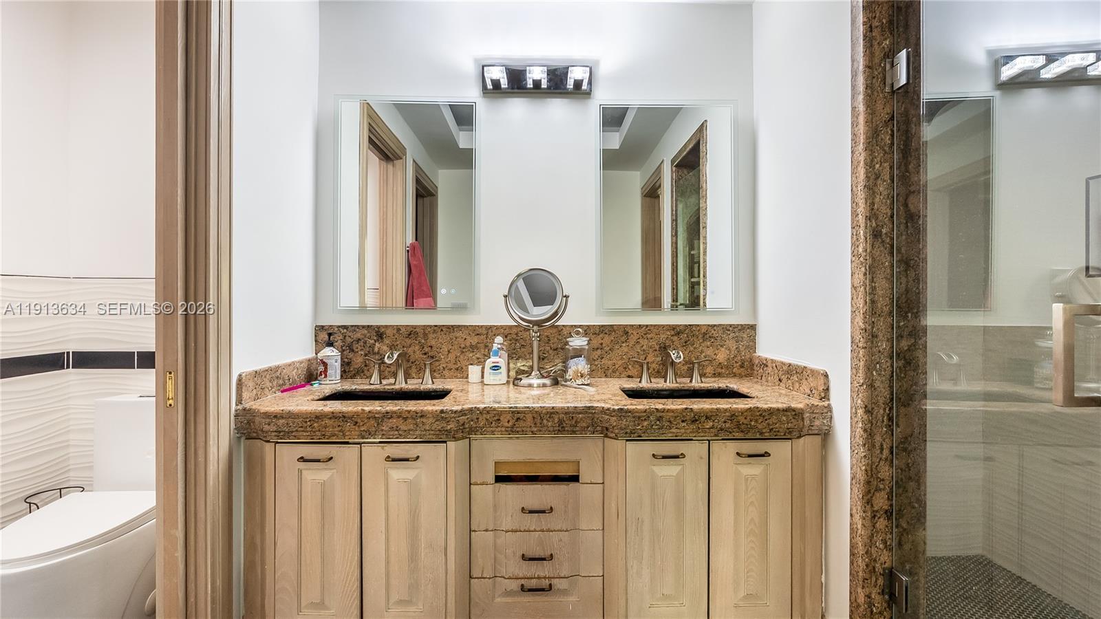10395 Southwest 67th Avenue Pinecrest, FL 33156 - Photo 74 of 94 a bathroom with a granite countertop sink and a mirror