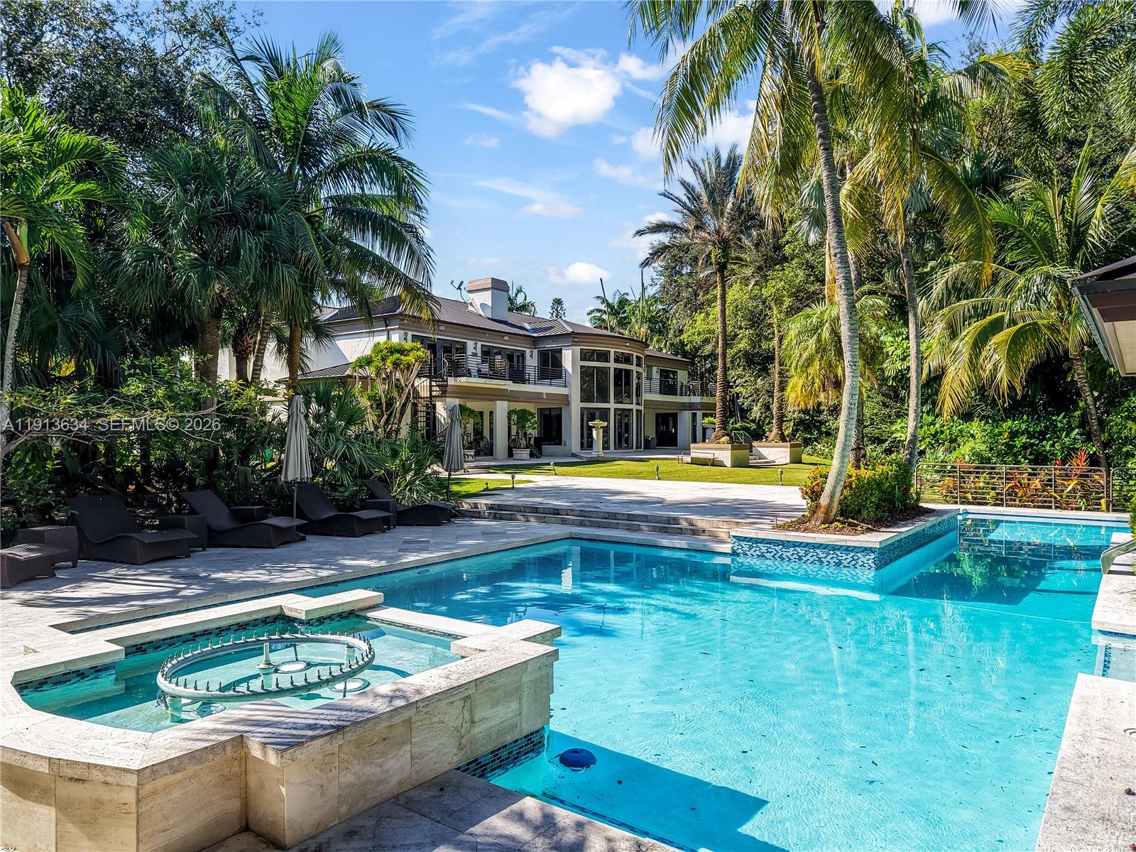 10395 Southwest 67th Avenue Pinecrest, FL 33156 - Photo 86 of 94 a view of swimming pool with lawn chairs and plants