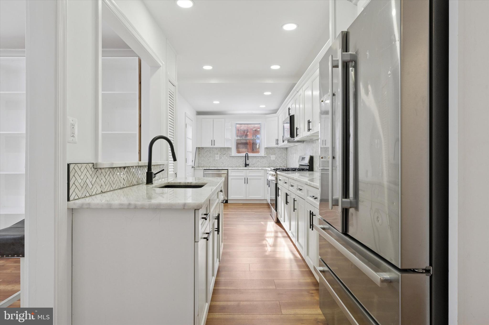 226 Upland Road Merion Station, PA 19066 - Photo 12 of 30 a kitchen with stainless steel appliances granite countertop a refrigerator a sink a stove and white cabinets with wooden floor