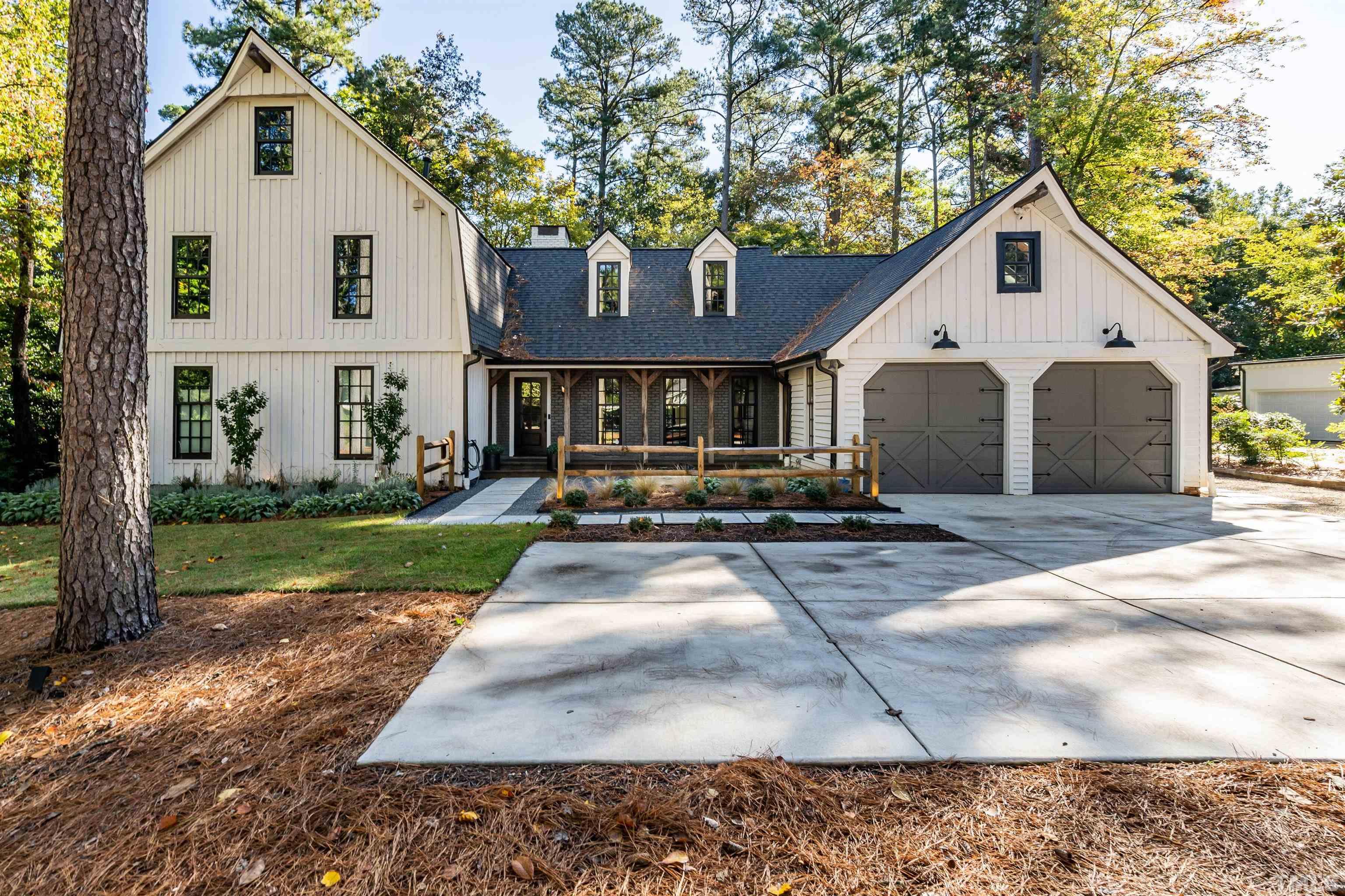 2412 Ridge Road Raleigh, NC 27612 - Photo 2 of 43 a view of a white house with a yard plants and large tree