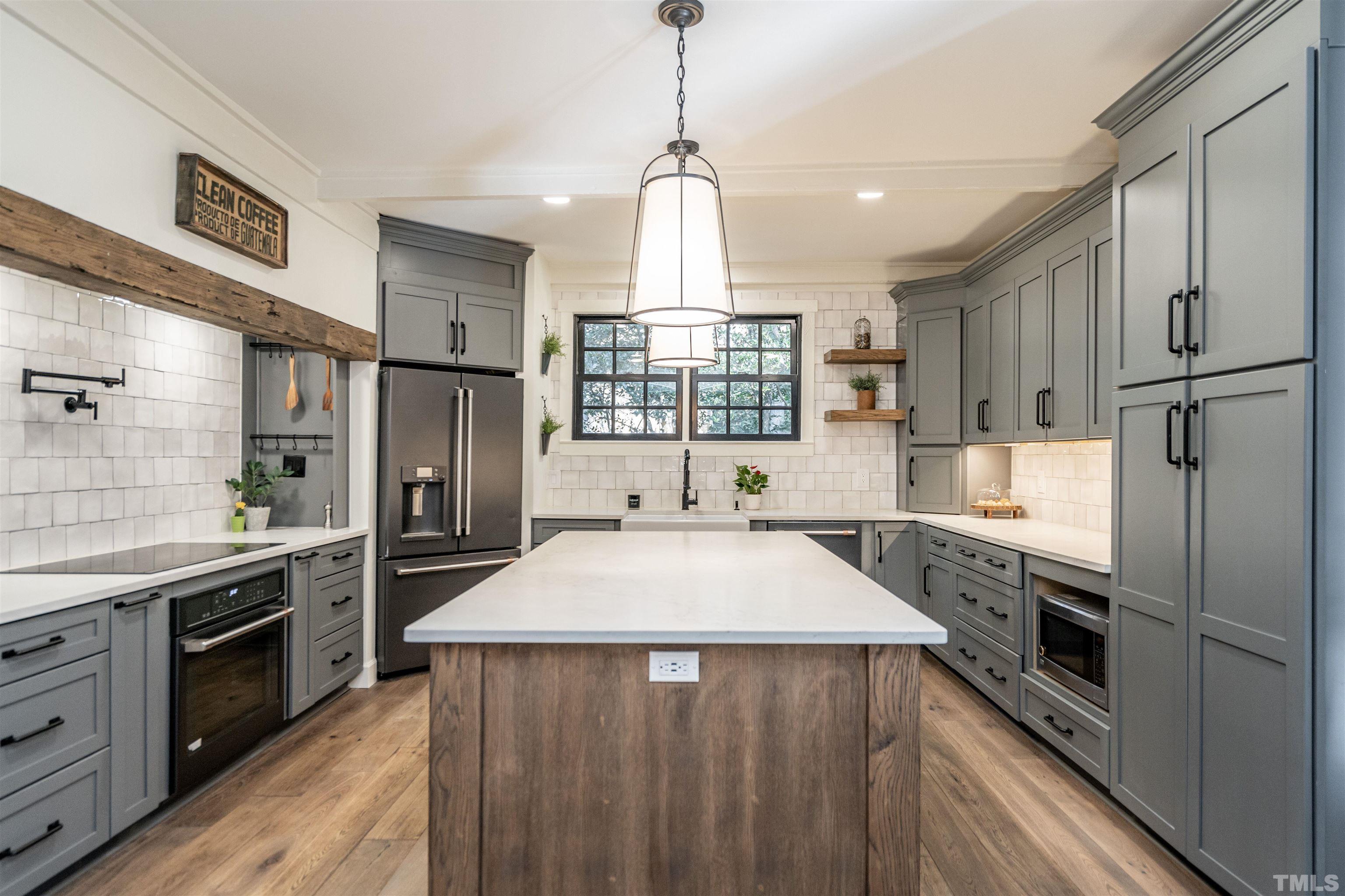 2412 Ridge Road Raleigh, NC 27612 - Photo 15 of 43 a kitchen with stainless steel appliances granite countertop a refrigerator a sink dishwasher a stove and white countertops with wooden floor
