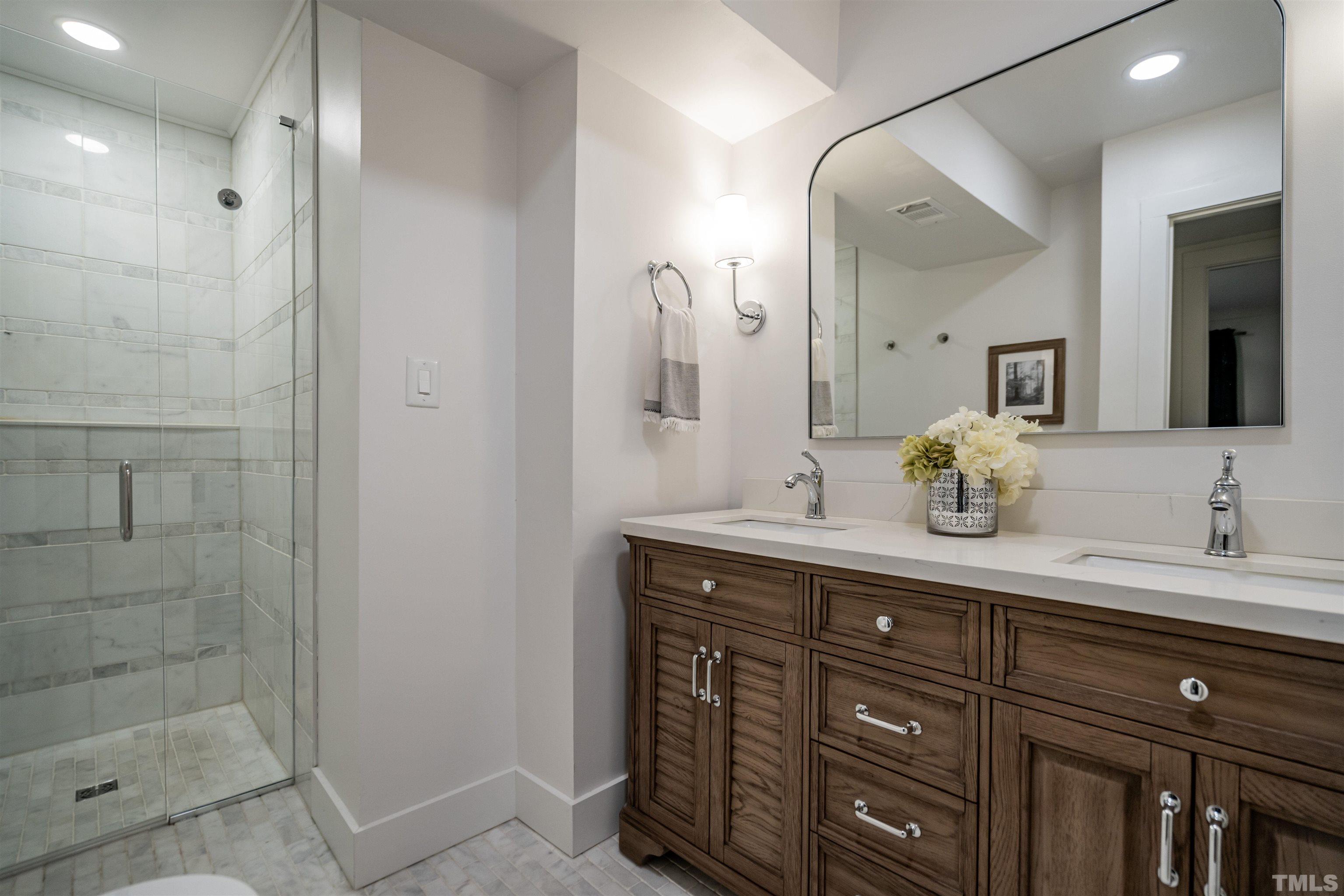2412 Ridge Road Raleigh, NC 27612 - Photo 33 of 43 a spacious bathroom with a granite countertop sink a mirror and a shower