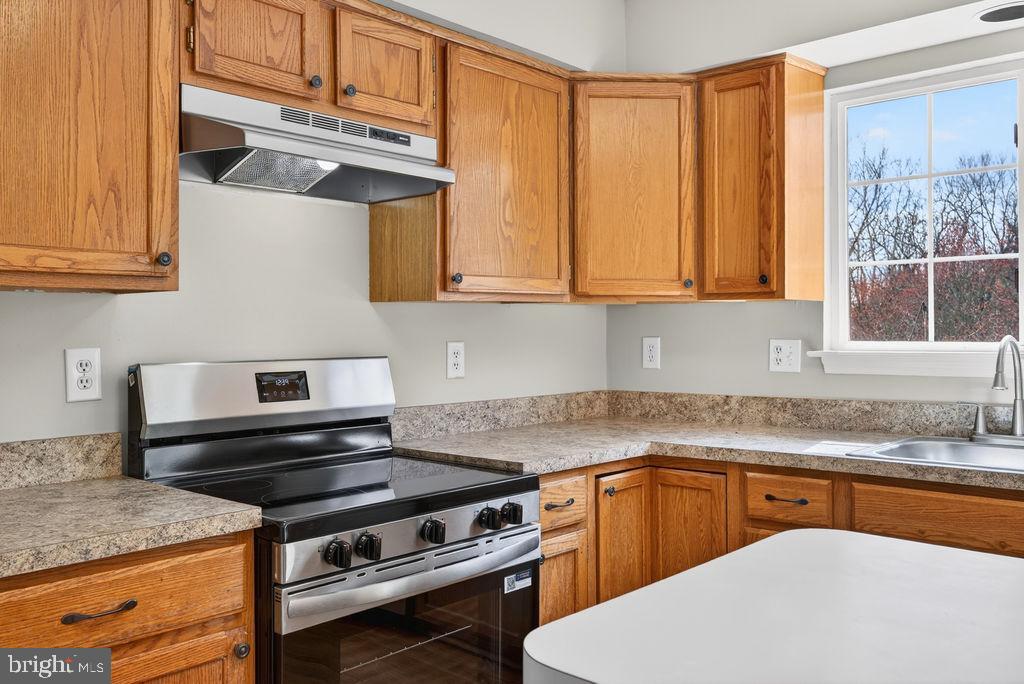 43249 Clearnight Terrace Ashburn, VA 20147 - Photo 14 of 39 a kitchen with stainless steel appliances granite countertop a stove a sink and a microwave