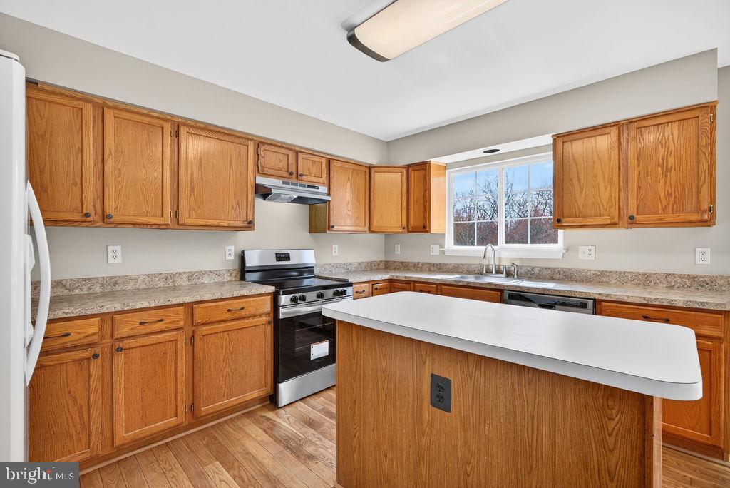 43249 Clearnight Terrace Ashburn, VA 20147 - Photo 16 of 39 a kitchen with stainless steel appliances granite countertop wooden cabinets a sink and a stove
