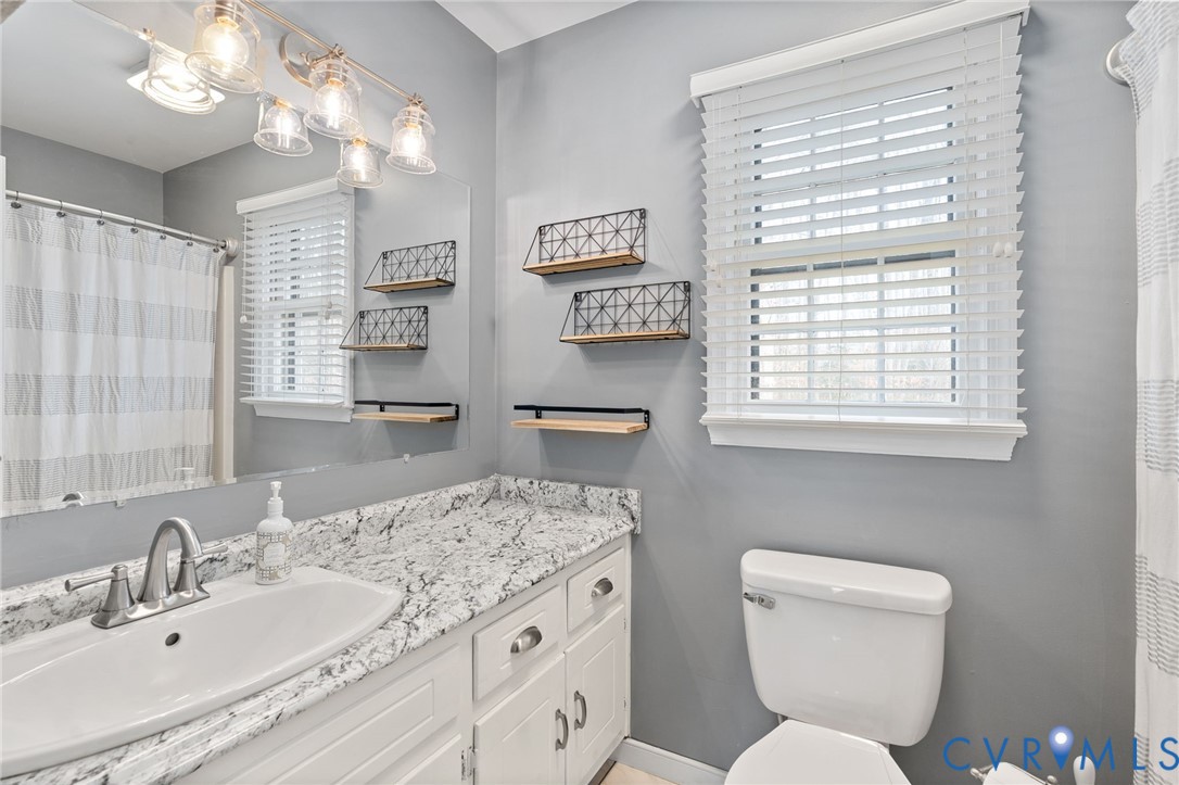 13642 Decidedly Court Midlothian, VA 23112 - Photo 23 of 35 a bathroom with a granite countertop toilet a sink and a mirror