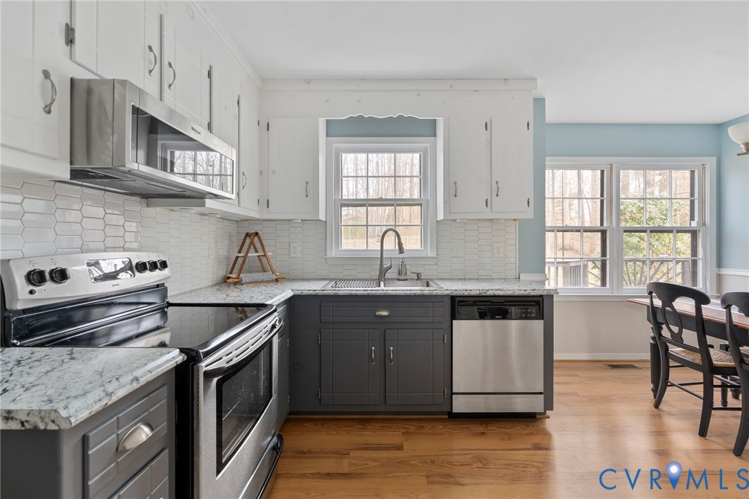 13642 Decidedly Court Midlothian, VA 23112 - Photo 10 of 35 a kitchen with granite countertop a sink stove and cabinets