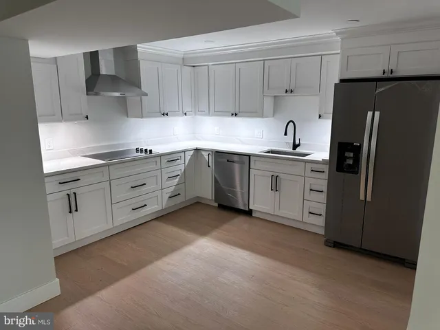a kitchen with stainless steel appliances granite countertop a refrigerator and a stove top oven