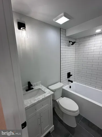 a white toilet sitting next to a bathroom sink and tub