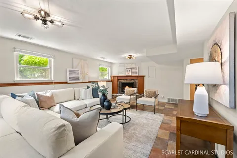 a living room with furniture a fireplace and a window
