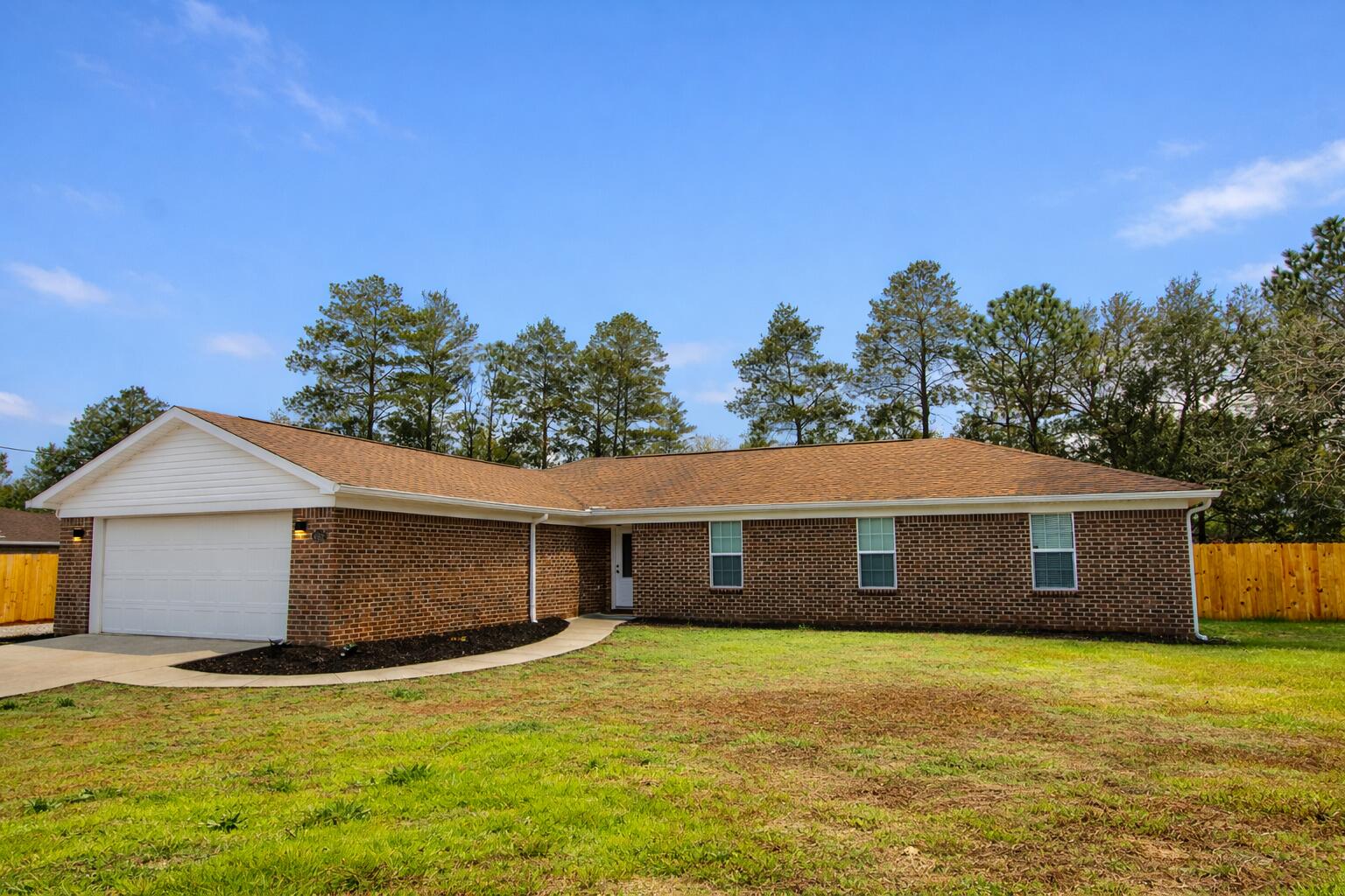 a front view of a house with a garden and yard