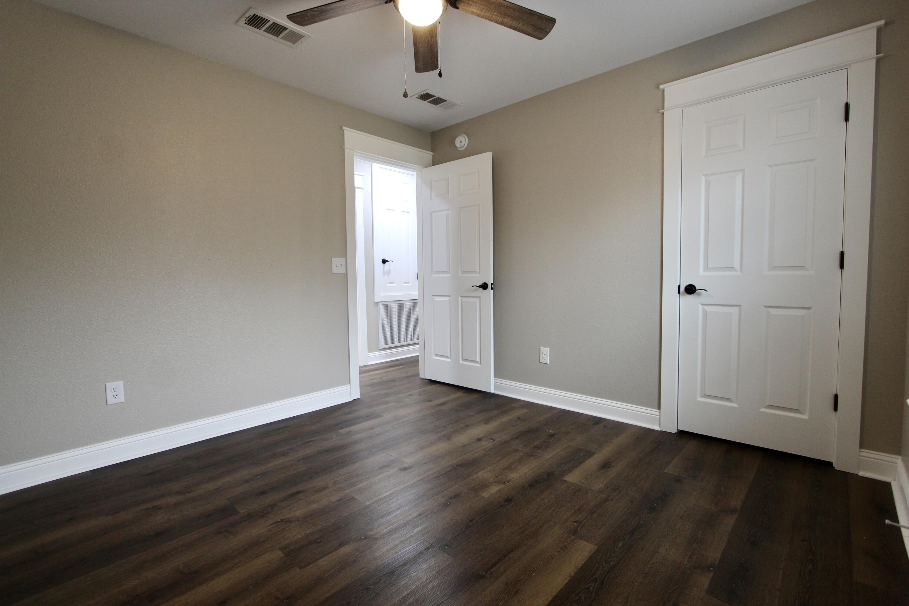 4052 Randi Road Crestview, FL 32539 - Photo 15 of 27 a view of an empty room with wooden floor a ceiling fan