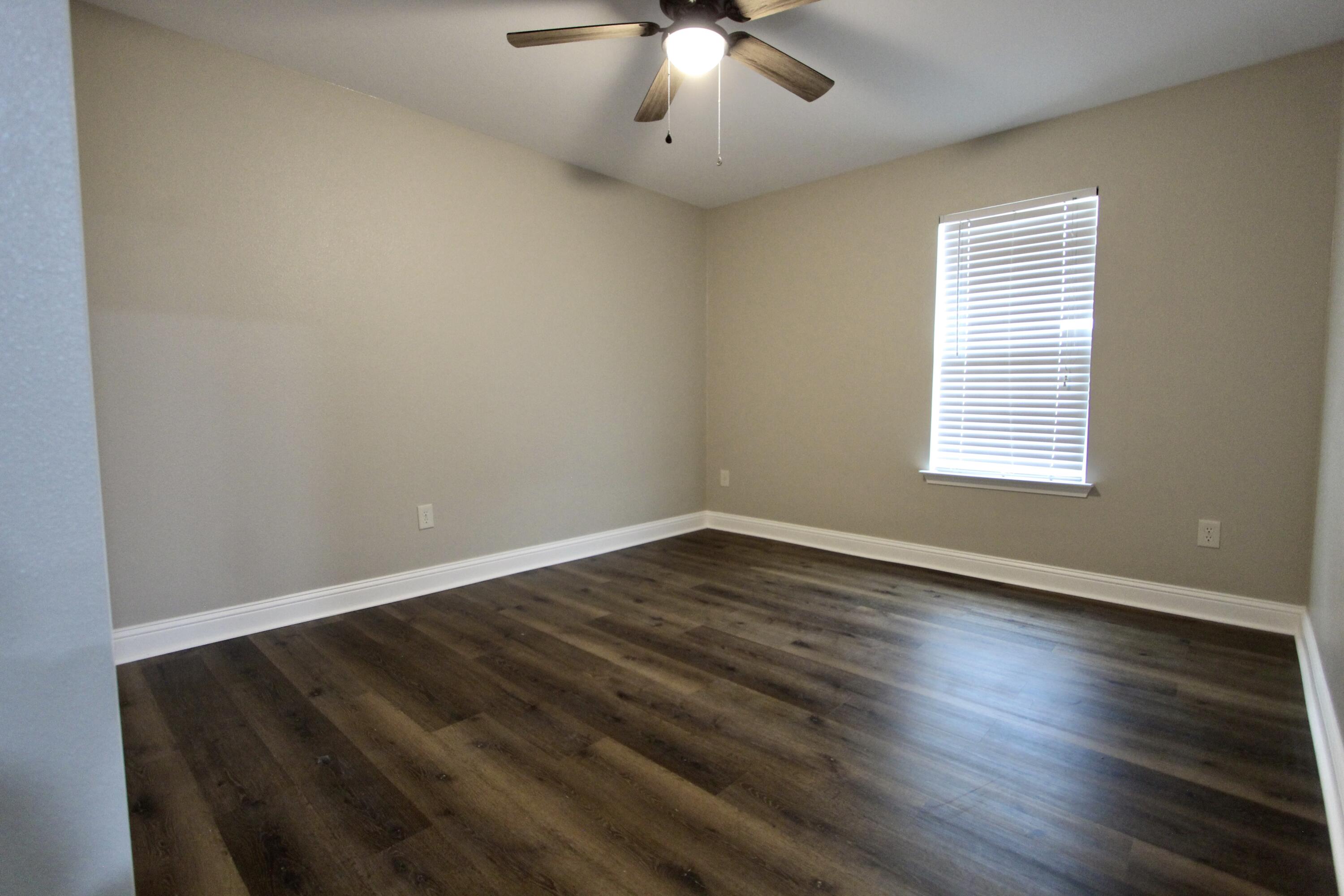 4052 Randi Road Crestview, FL 32539 - Photo 17 of 27 a view of an empty room with wooden floor and a window