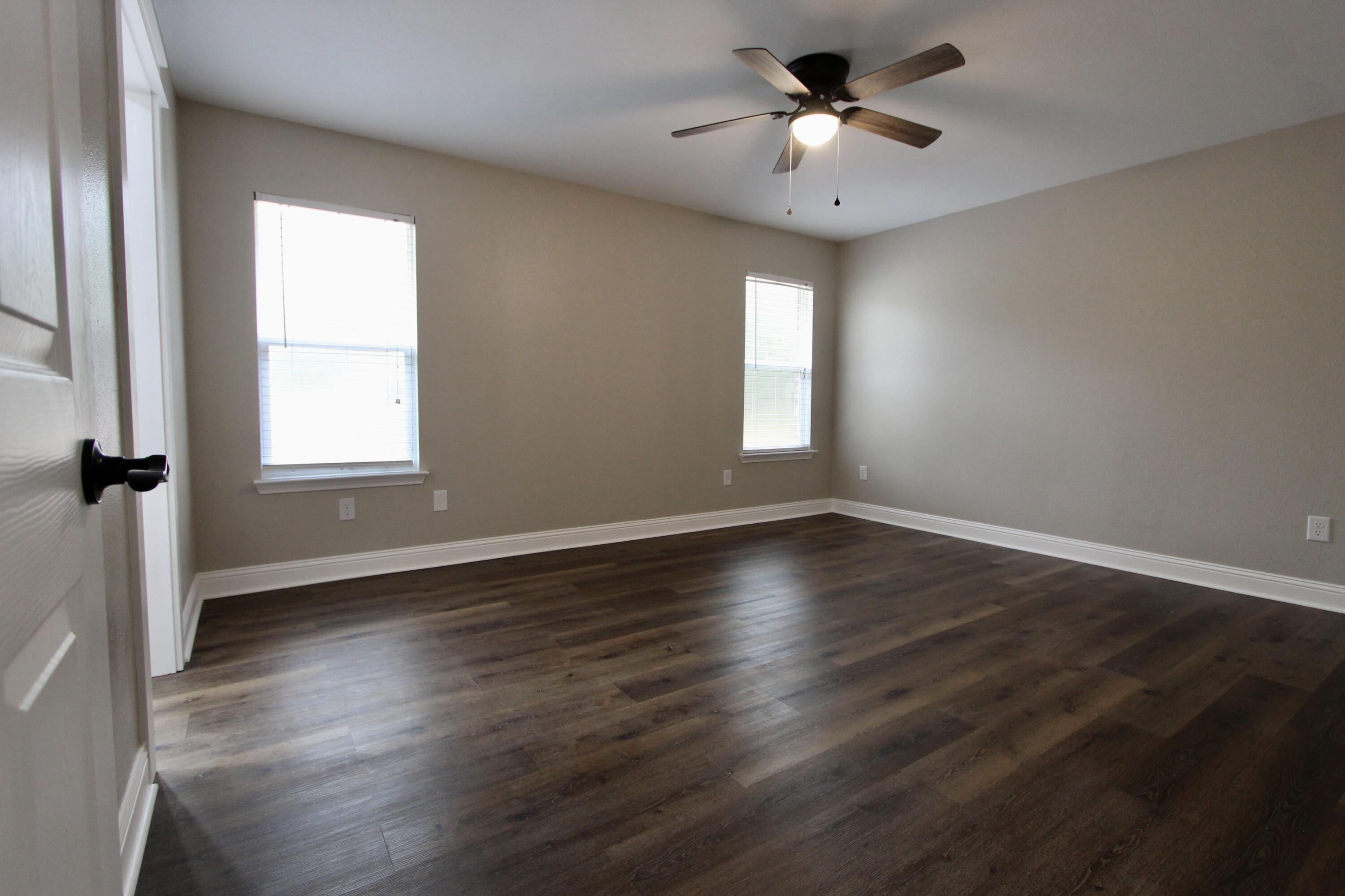 4052 Randi Road Crestview, FL 32539 - Photo 20 of 27 an empty room with wooden floor and windows